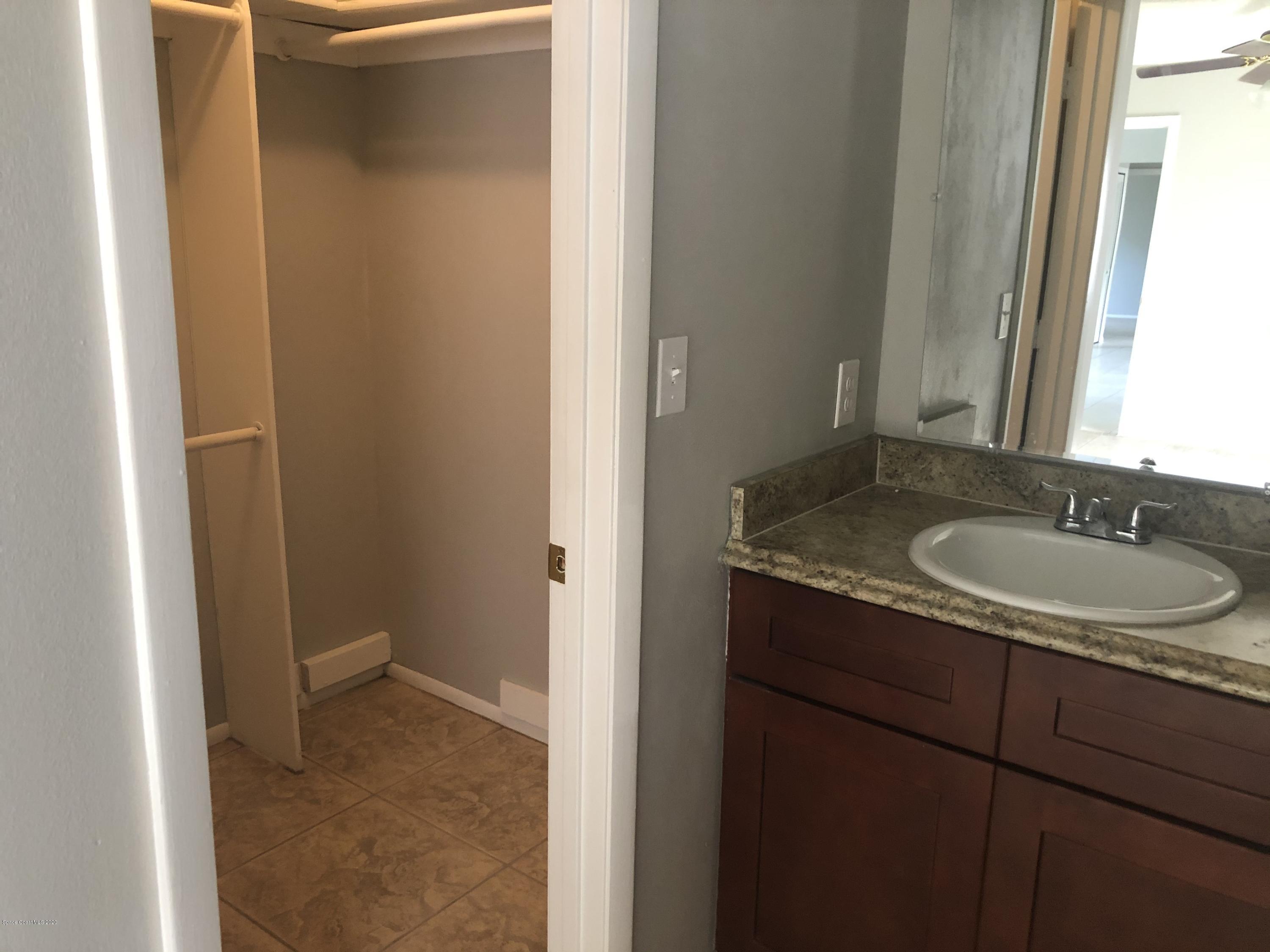 242 Sarah Road Southwest Palm Bay, FL 32908 - Photo 14 of 27 a bathroom with a granite countertop sink and a mirror