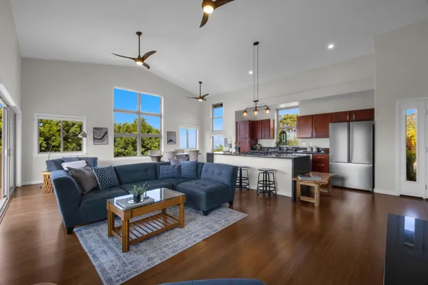 a living room with furniture kitchen view and a window