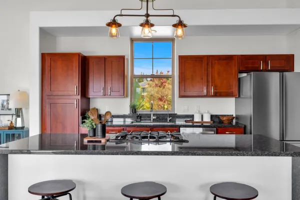 a kitchen with stainless steel appliances granite countertop a sink a counter space and cabinets