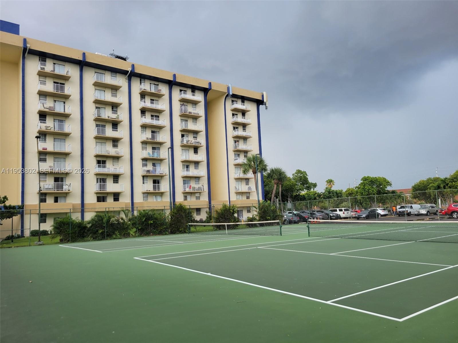 4550 Northwest 9th Street, Unit 315E Miami, FL 33126 - Photo 13 of 15 a view of a tall building with a big yard and plants