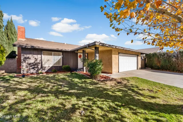 a view of a hallway with wooden floor and a living room