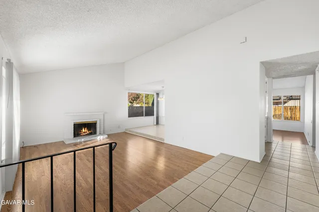 a view of an empty room with window and fire place