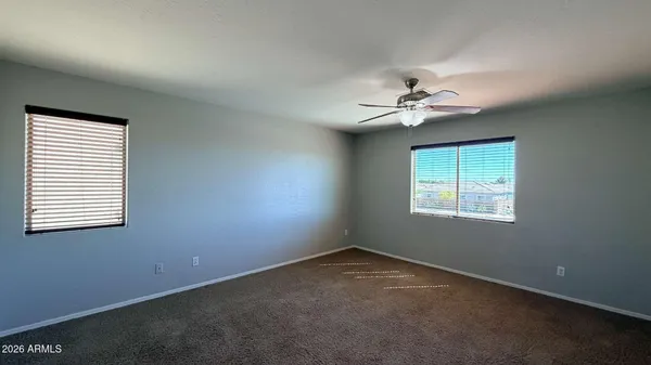 an empty room with windows and fan