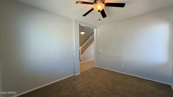 an empty room with windows and fan