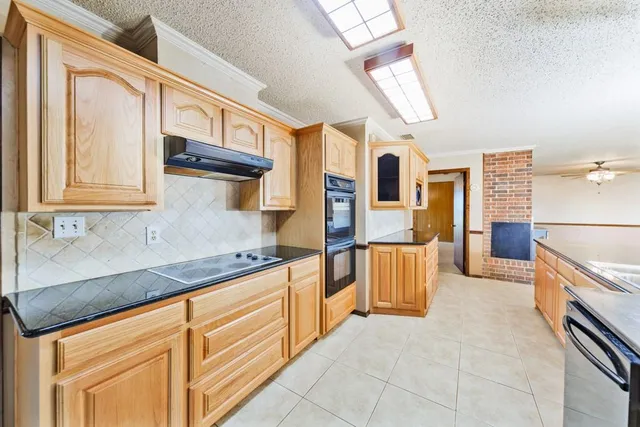a kitchen with granite countertop a sink and cabinets