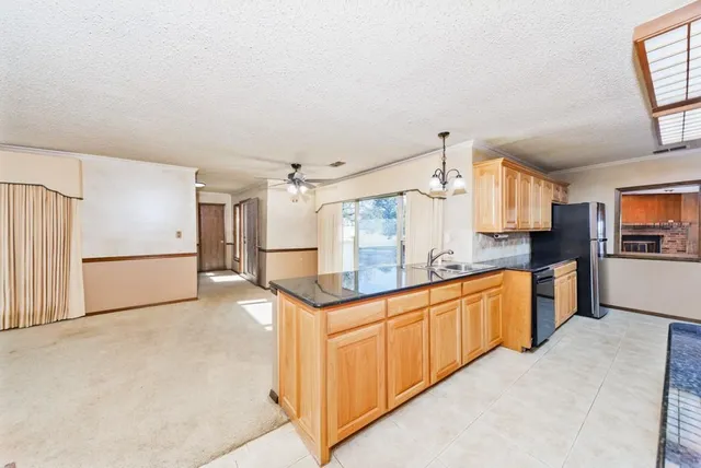 a kitchen with granite countertop a refrigerator and a sink