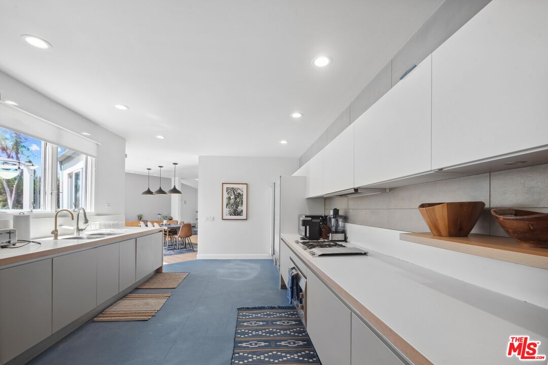 23400 West Moon Shadows Drive Malibu, CA 90265 - Photo 13 of 31 a kitchen with stainless steel appliances a sink a stove a refrigerator and cabinets