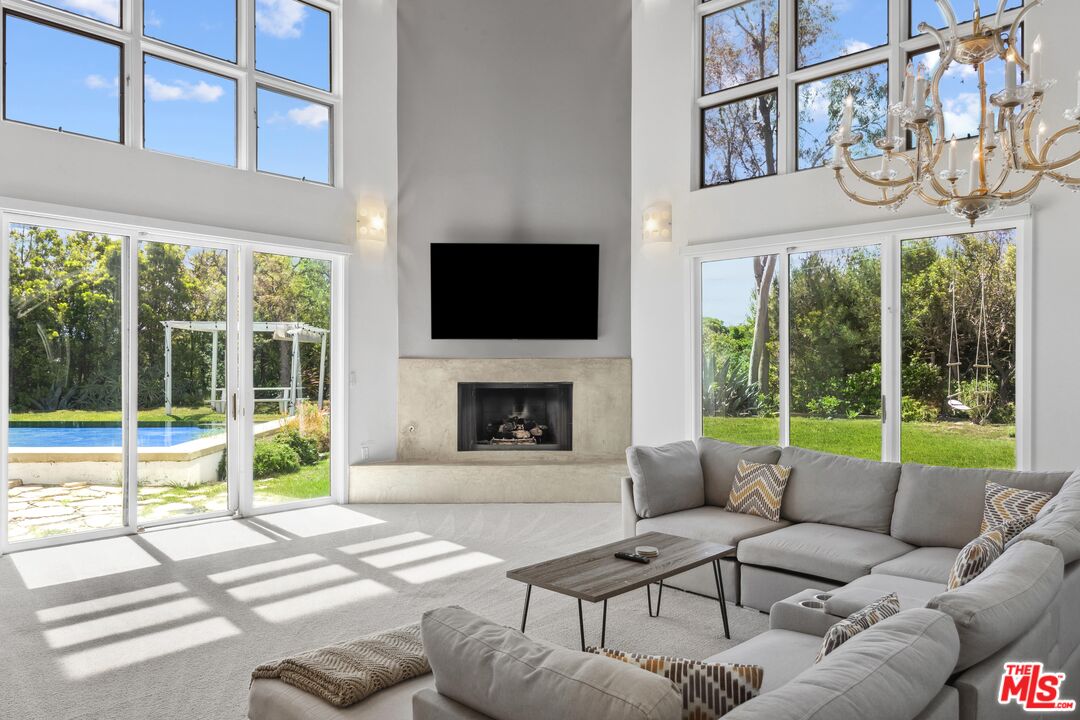 23400 West Moon Shadows Drive Malibu, CA 90265 - Photo 15 of 31 a living room with furniture a fireplace and a large window