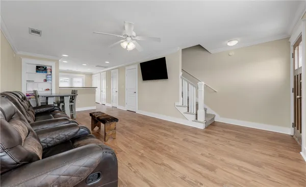 a living room with furniture a chandelier and a dining table