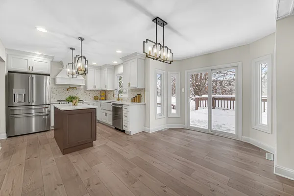 a large kitchen with chandelier and stainless steel appliances