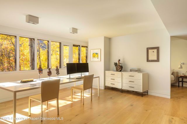 a view of a workspace with furniture and a window
