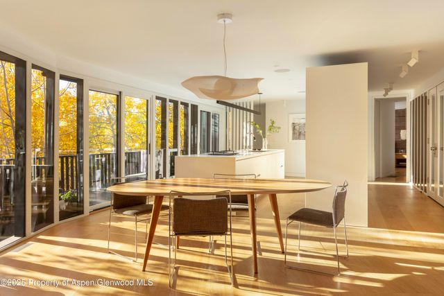 a view of a dining room with furniture large windows and wooden floor