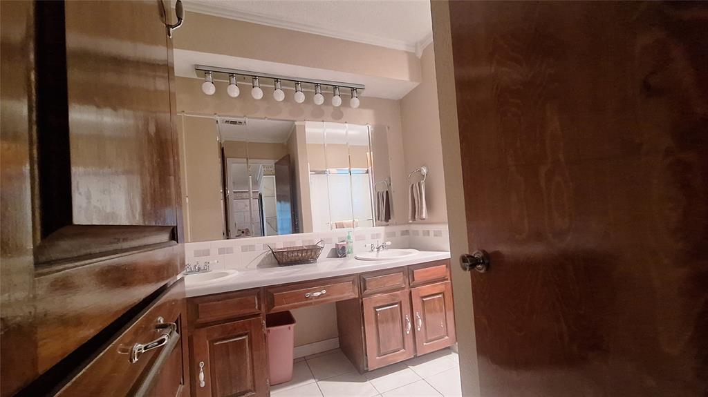613 Colts Neck Court Colleyville, TX 76034 - Photo 31 of 38 upstairs ensuite bath ilinen closet, makeup vanity between 2 sinks, wall linen closet & shower with sliding glass doors