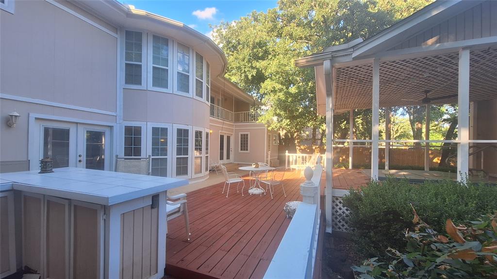 613 Colts Neck Court Colleyville, TX 76034 - Photo 5 of 38 extensive concrete and redwood deck along back of home perfect for outdoor entertainment with kitchen door and 2 french doors into living and master suite. 2nd floor balcony leads to 11x11 concrete deck treetop patio