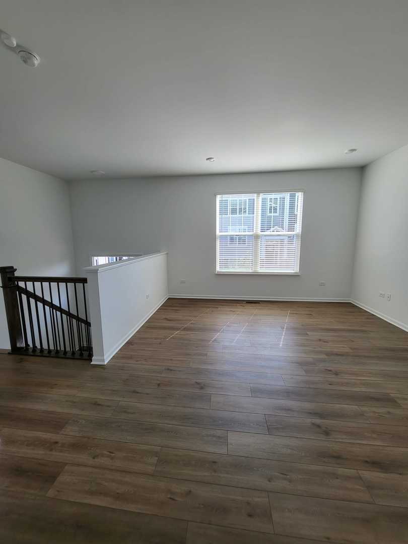 588 Wolverine Drive Aurora, IL 60502 - Photo 14 of 29 an empty room with wooden floor and windows