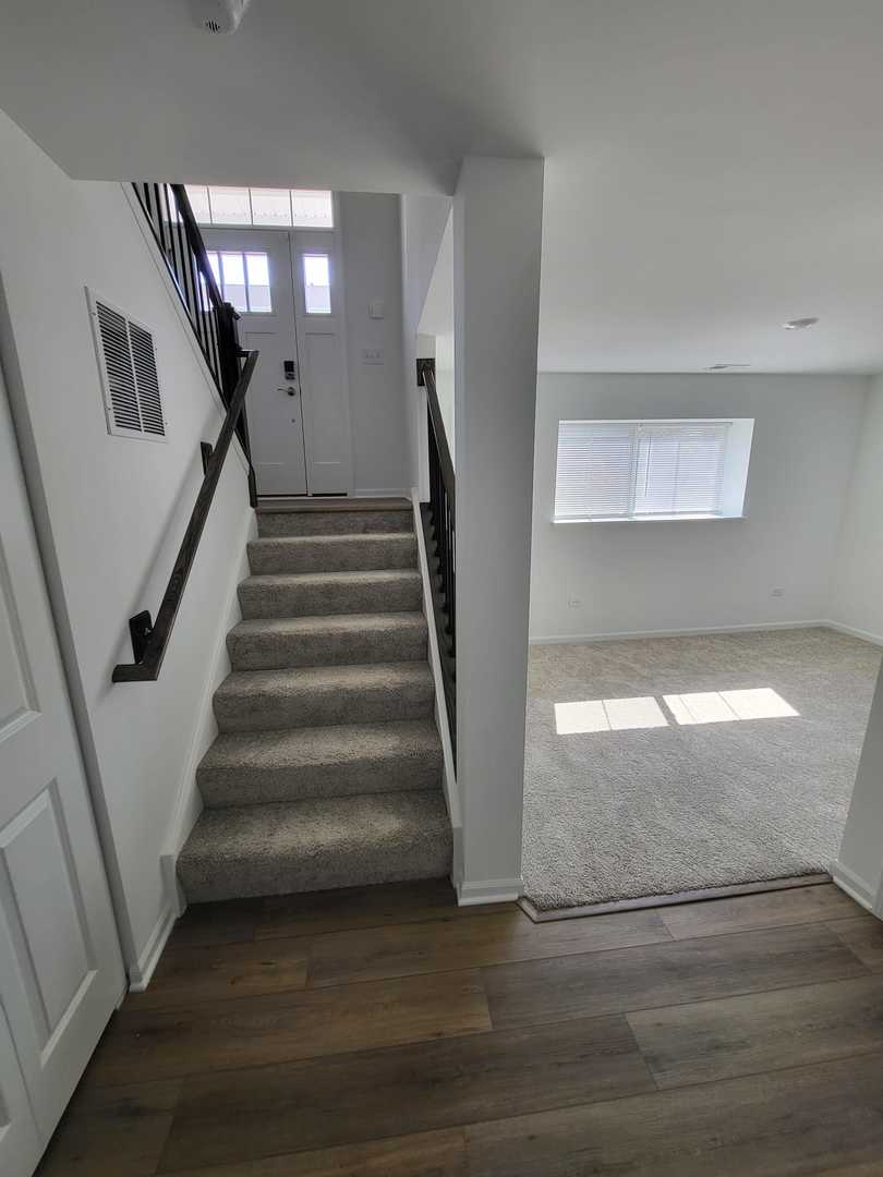 588 Wolverine Drive Aurora, IL 60502 - Photo 15 of 29 a view of staircase with lots of frames on wall and stairs