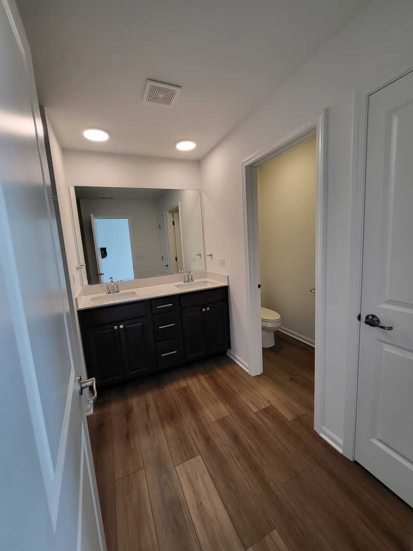 588 Wolverine Drive Aurora, IL 60502 - Photo 25 of 29 a bathroom with a double vanity sink and a mirror
