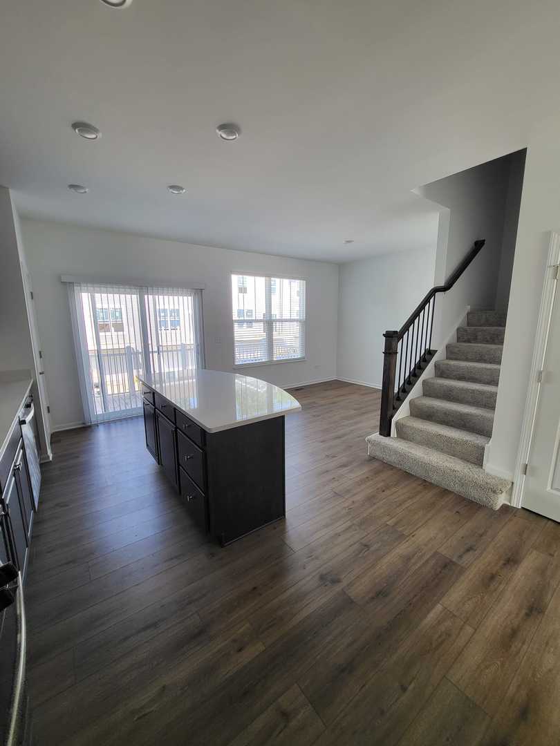 588 Wolverine Drive Aurora, IL 60502 - Photo 6 of 29 an empty room with wooden floor and windows