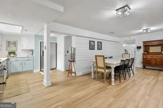 a view of a hallway with wooden floor and cabinet