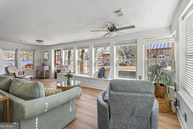 a bedroom with a large bed a chandelier and a flat tv screen on dresser
