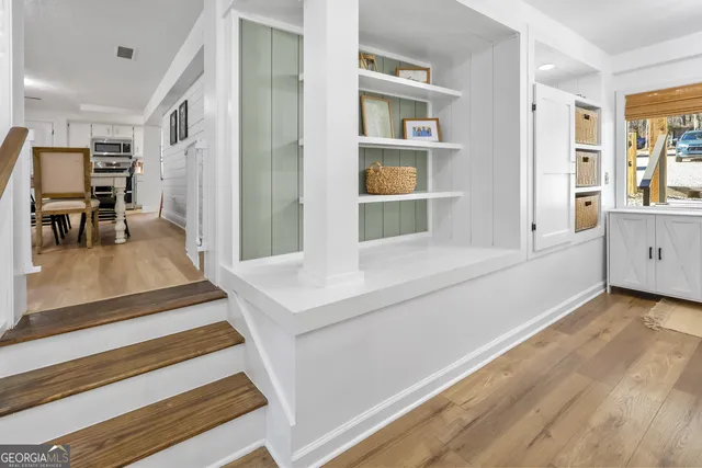 a large kitchen with cabinets wooden floor and stainless steel appliances