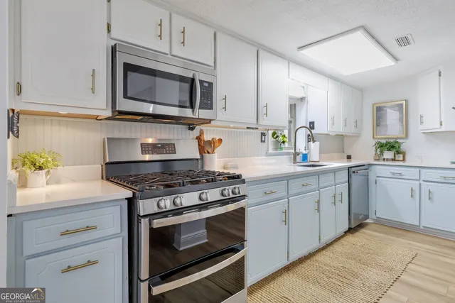 a kitchen with cabinets and wooden floor