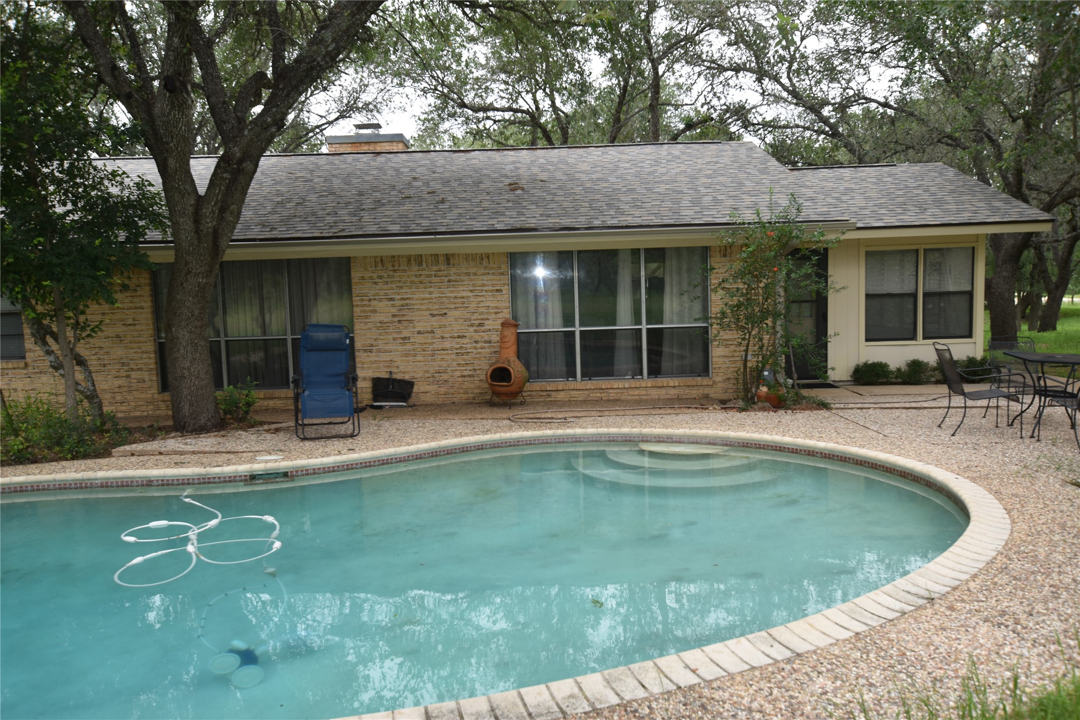 687 Fm 812 Road Red Rock, TX 78662 - Photo 20 of 40 Kidney-shaped swimming pool featuring integrated steps and a surrounding patio