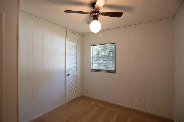 a view of a room with a hanging light and hardwood