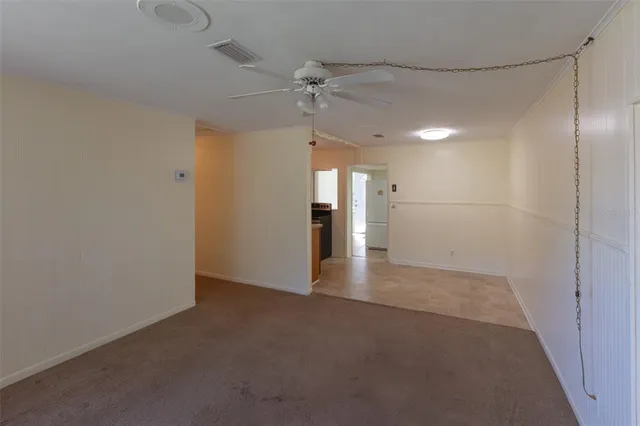 a view of a empty room with a ceiling fan