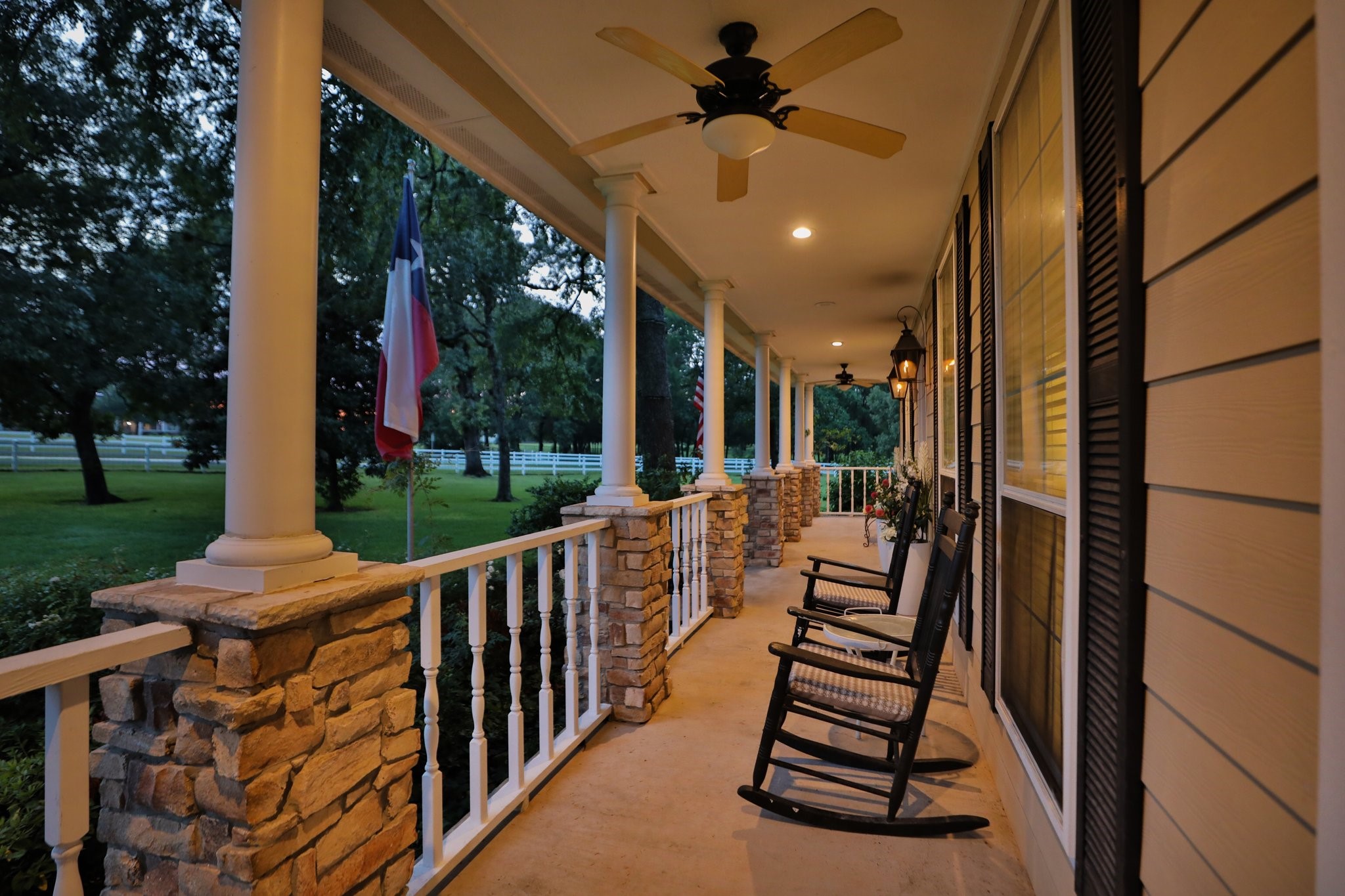 34310 High Point Drive Magnolia, TX 77355 - Photo 6 of 48 This inviting home features a spacious front porch with stone pillars, ceiling fans, perfect for relaxing. Surrounded by lush greenery it offers a serene setting for outdoor enjoyment.