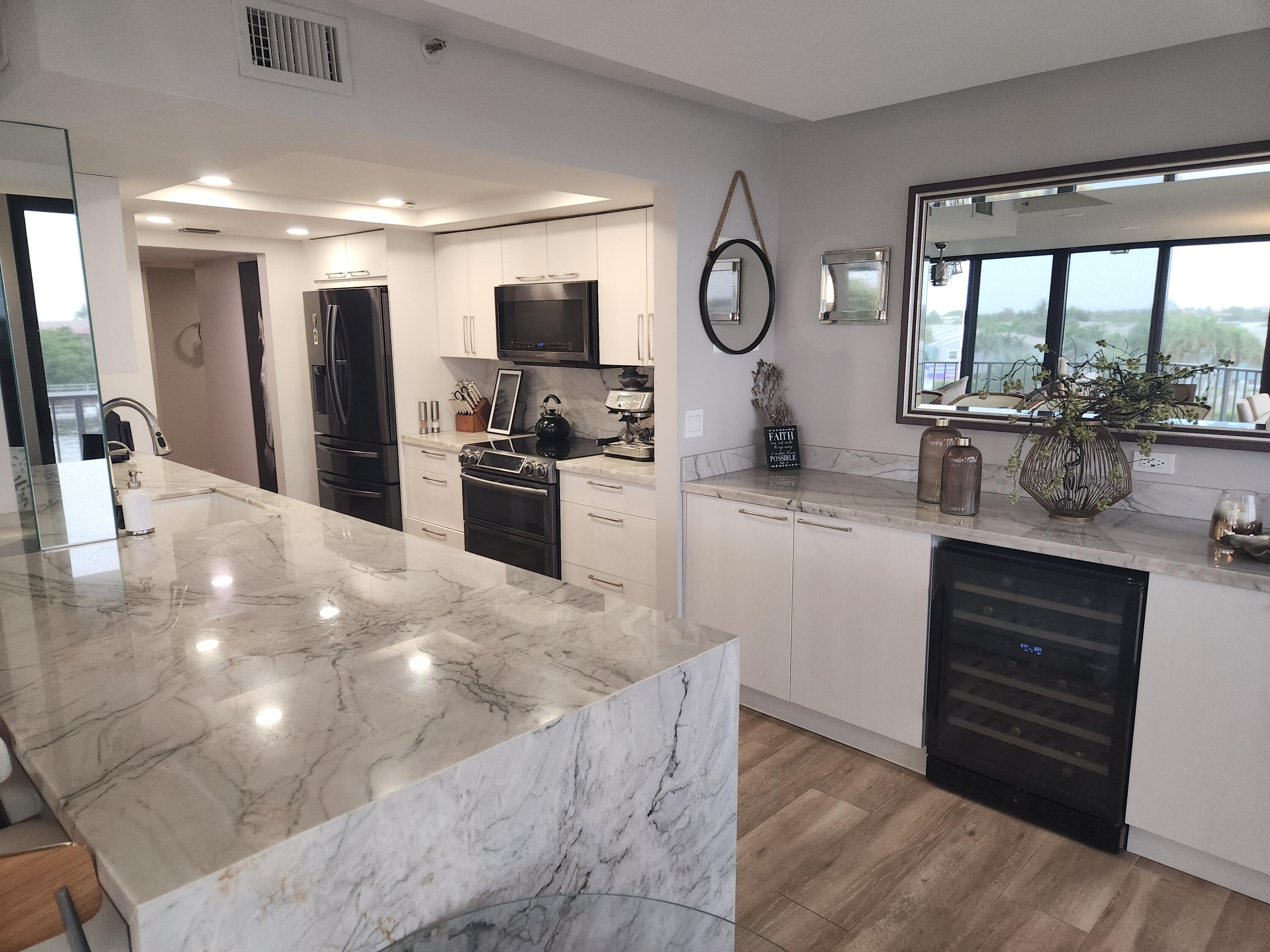899 Jeffery Street, Unit 4150 Boca Raton, FL 33487 - Photo 3 of 38 a kitchen with stainless steel appliances a refrigerator and a stove top oven