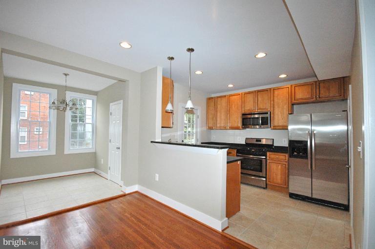 a kitchen with stainless steel appliances granite countertop a refrigerator a sink a stove and oven