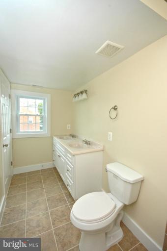 804 Rittenhouse Street Northwest Washington, DC 20011 - Photo 22 of 30 a bathroom with a granite countertop toilet a sink and a window