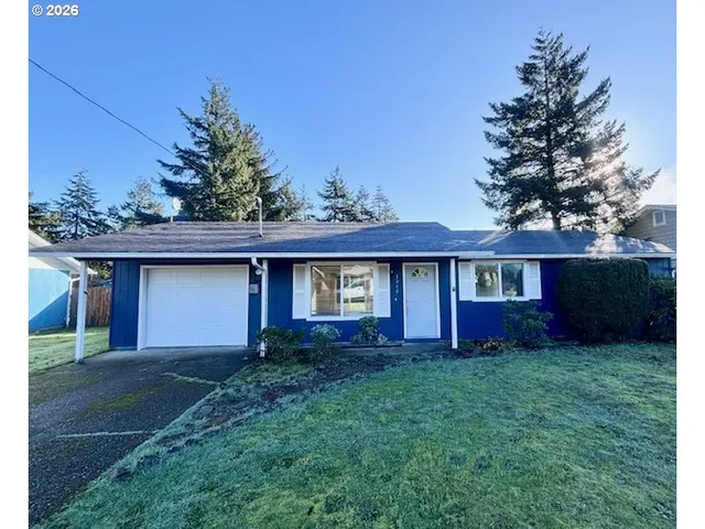 a view of a yard in front of a house with large tree
