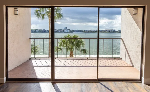 a view of a room with a large window and wooden floor