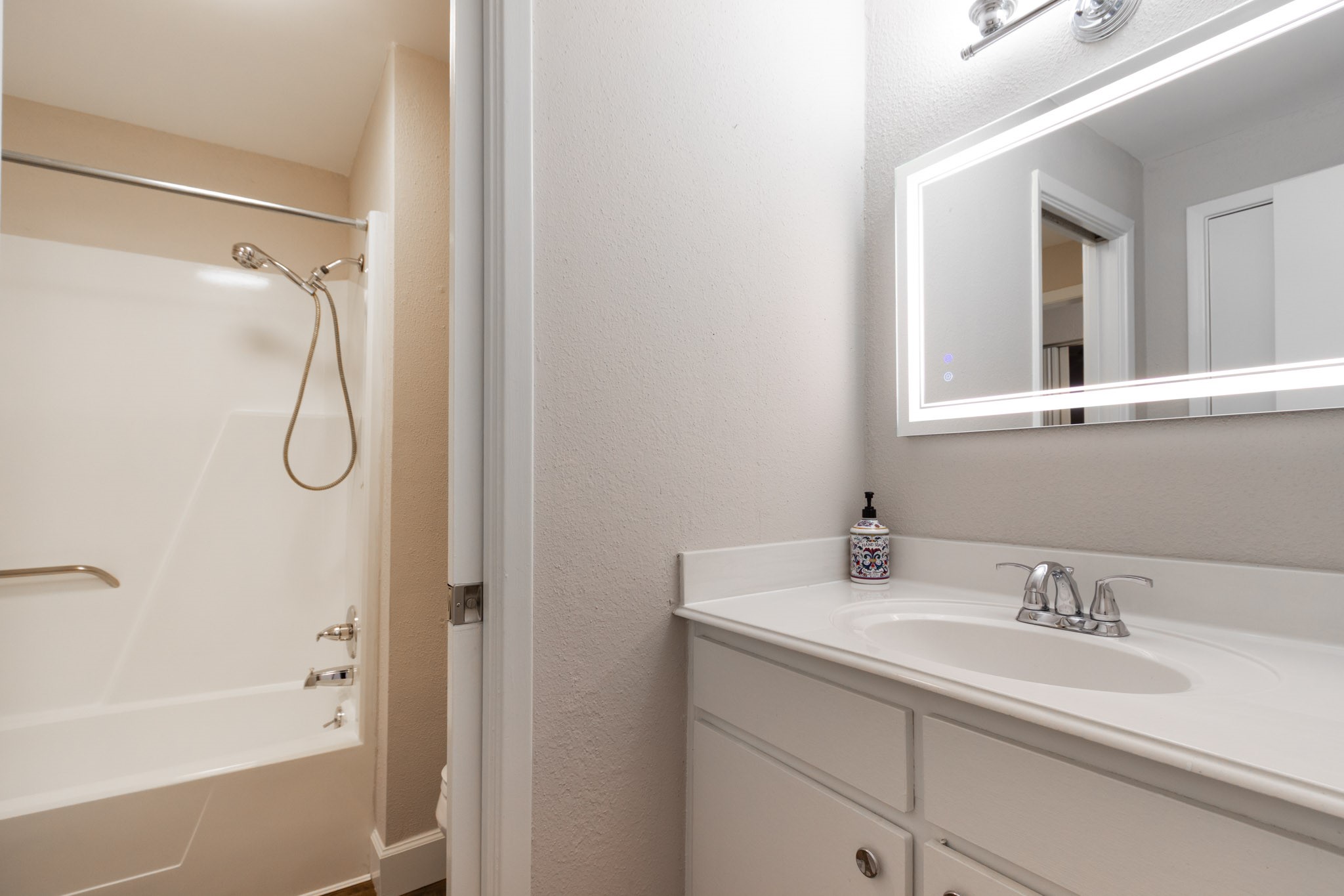 401 Lakeside Lane, Unit 111 Nassau Bay, TX 77058 - Photo 26 of 45 a bathroom with a granite countertop sink a mirror a vanity and shower