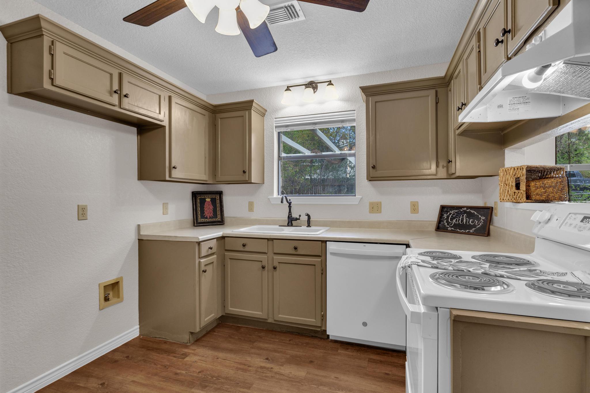 7902 Bar K Ranch Road Lago Vista, TX 78645 - Photo 11 of 35 Kitchen with white appliances, ceiling fan, light countertops, dark wood finished floors, and a textured ceiling
