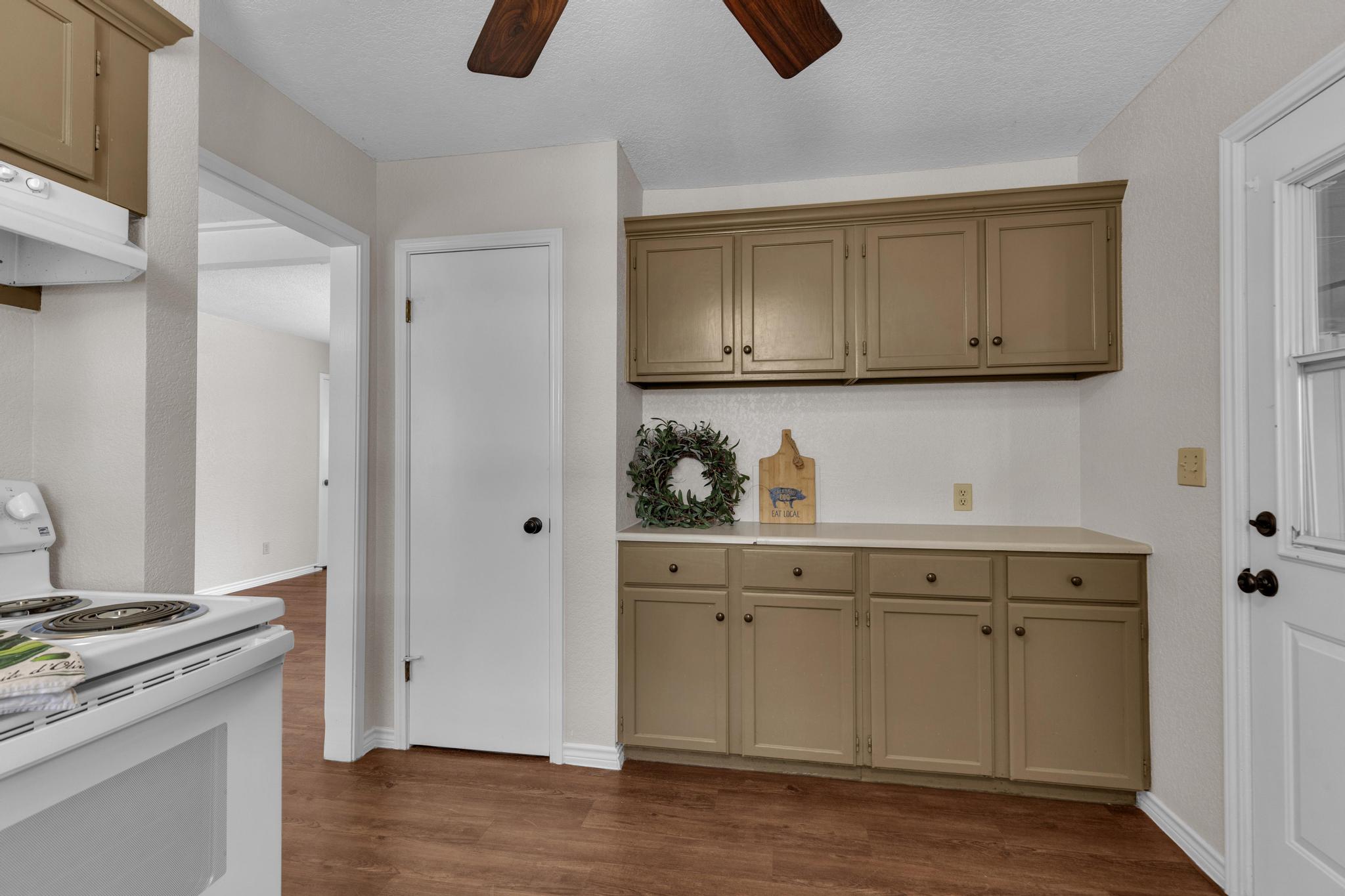 7902 Bar K Ranch Road Lago Vista, TX 78645 - Photo 14 of 35 Kitchen with electric stove, ceiling fan, light countertops, and dark wood-style flooring