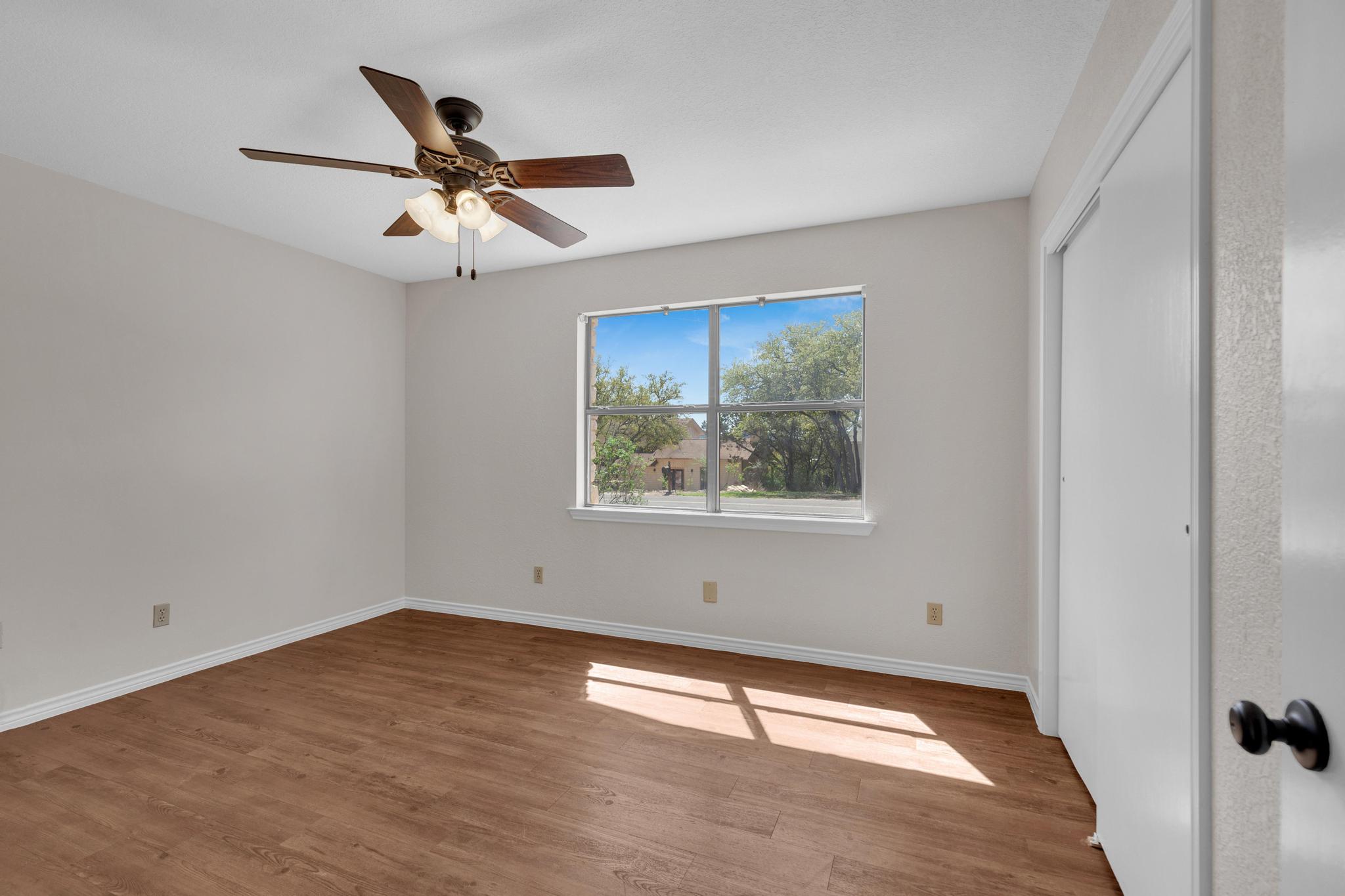 7902 Bar K Ranch Road Lago Vista, TX 78645 - Photo 15 of 35 Unfurnished bedroom featuring wood finished floors, a closet, and ceiling fan
