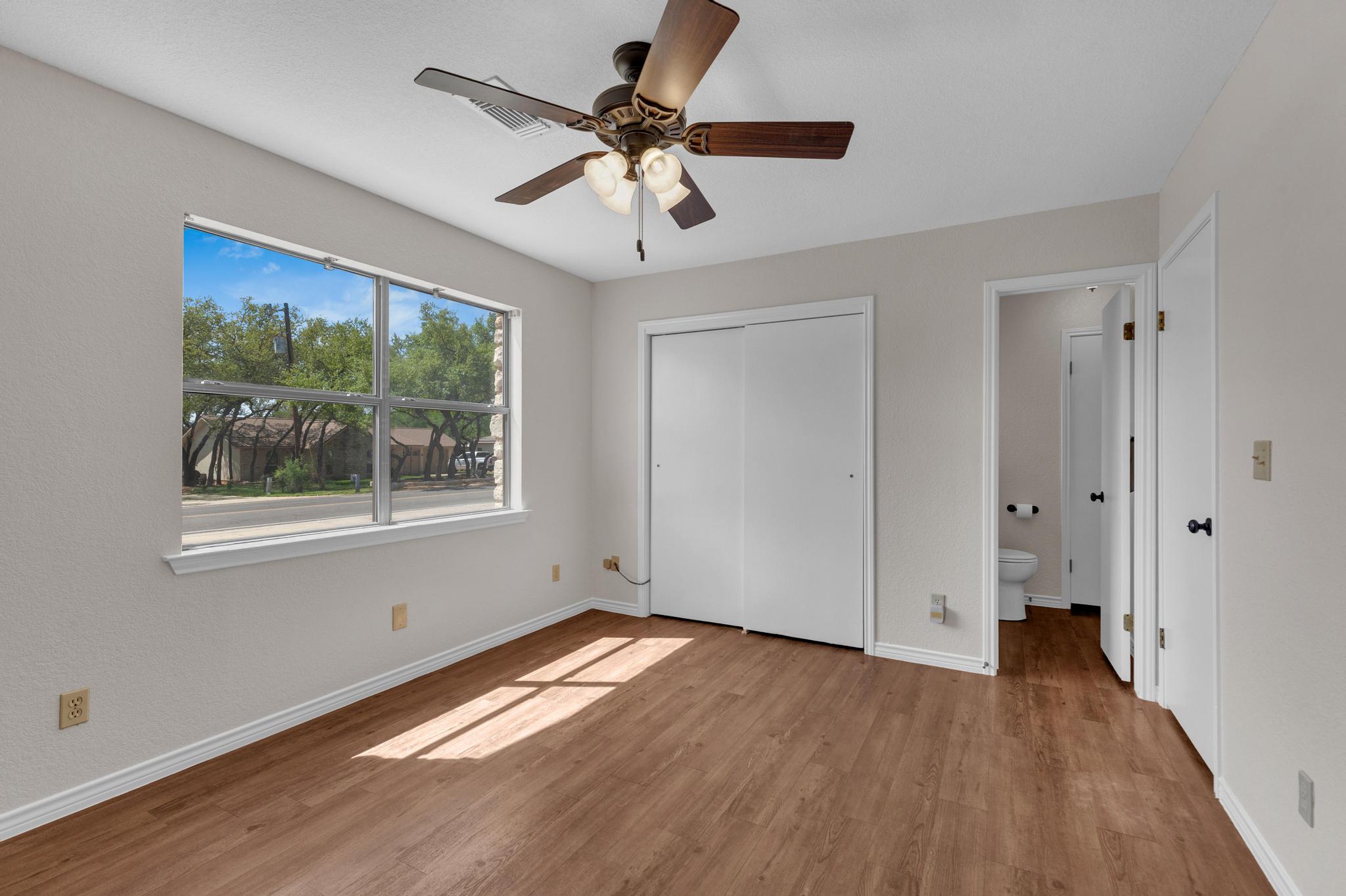 7902 Bar K Ranch Road Lago Vista, TX 78645 - Photo 16 of 35 Unfurnished bedroom with light wood-style flooring, a closet, and ceiling fan