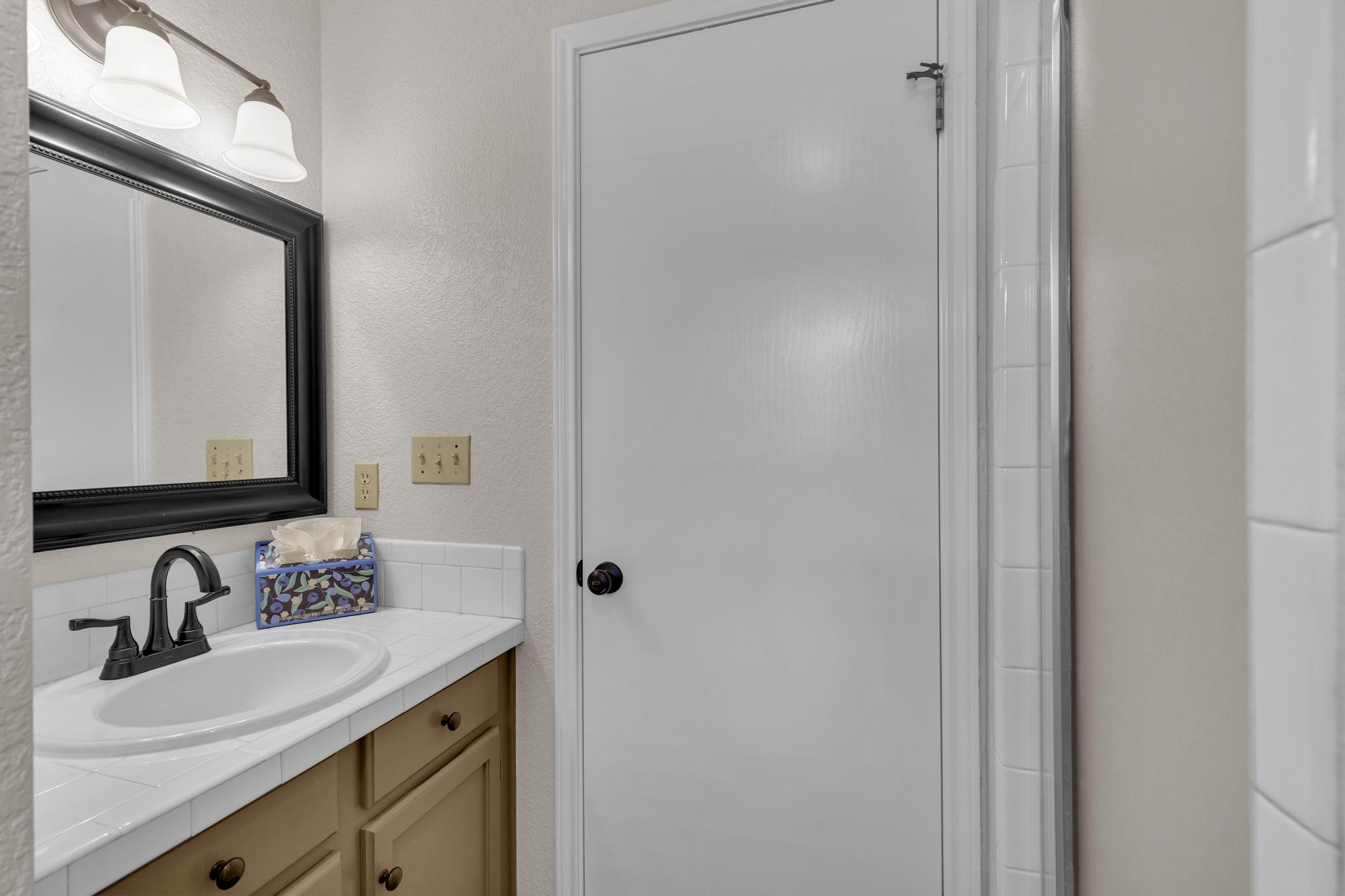 7902 Bar K Ranch Road Lago Vista, TX 78645 - Photo 18 of 35 Full bathroom featuring vanity, a textured wall, and an enclosed shower
