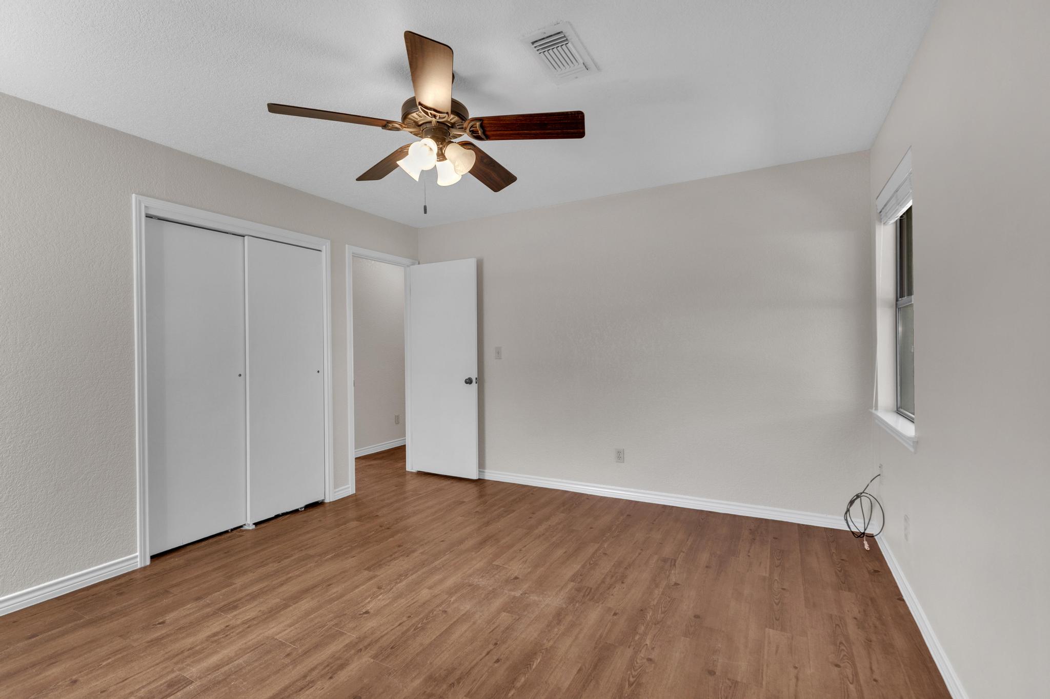 7902 Bar K Ranch Road Lago Vista, TX 78645 - Photo 20 of 35 Unfurnished bedroom with ceiling fan, wood finished floors, and a closet