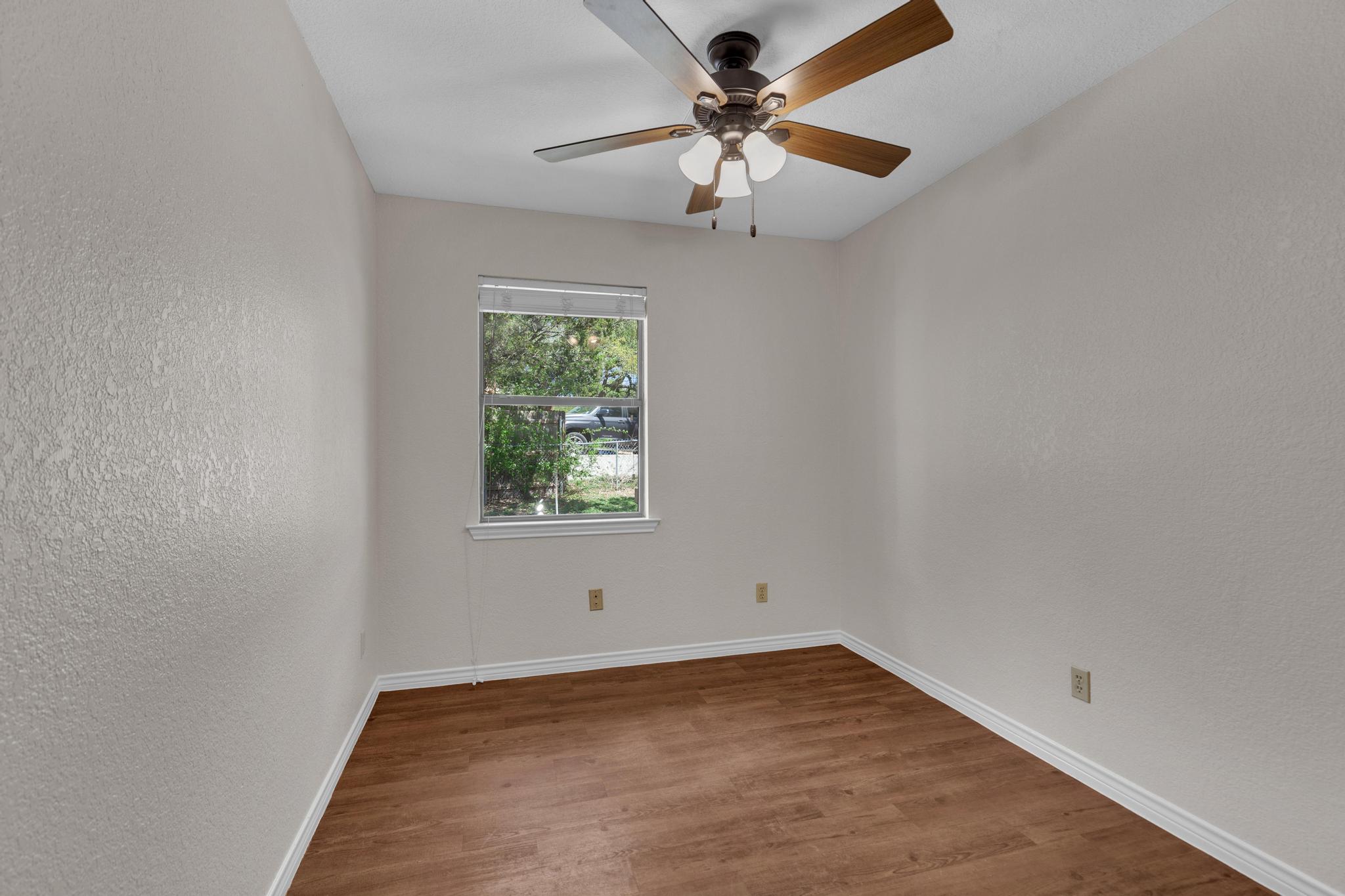 7902 Bar K Ranch Road Lago Vista, TX 78645 - Photo 22 of 35 Spare room with a textured wall, dark wood finished floors, and ceiling fan