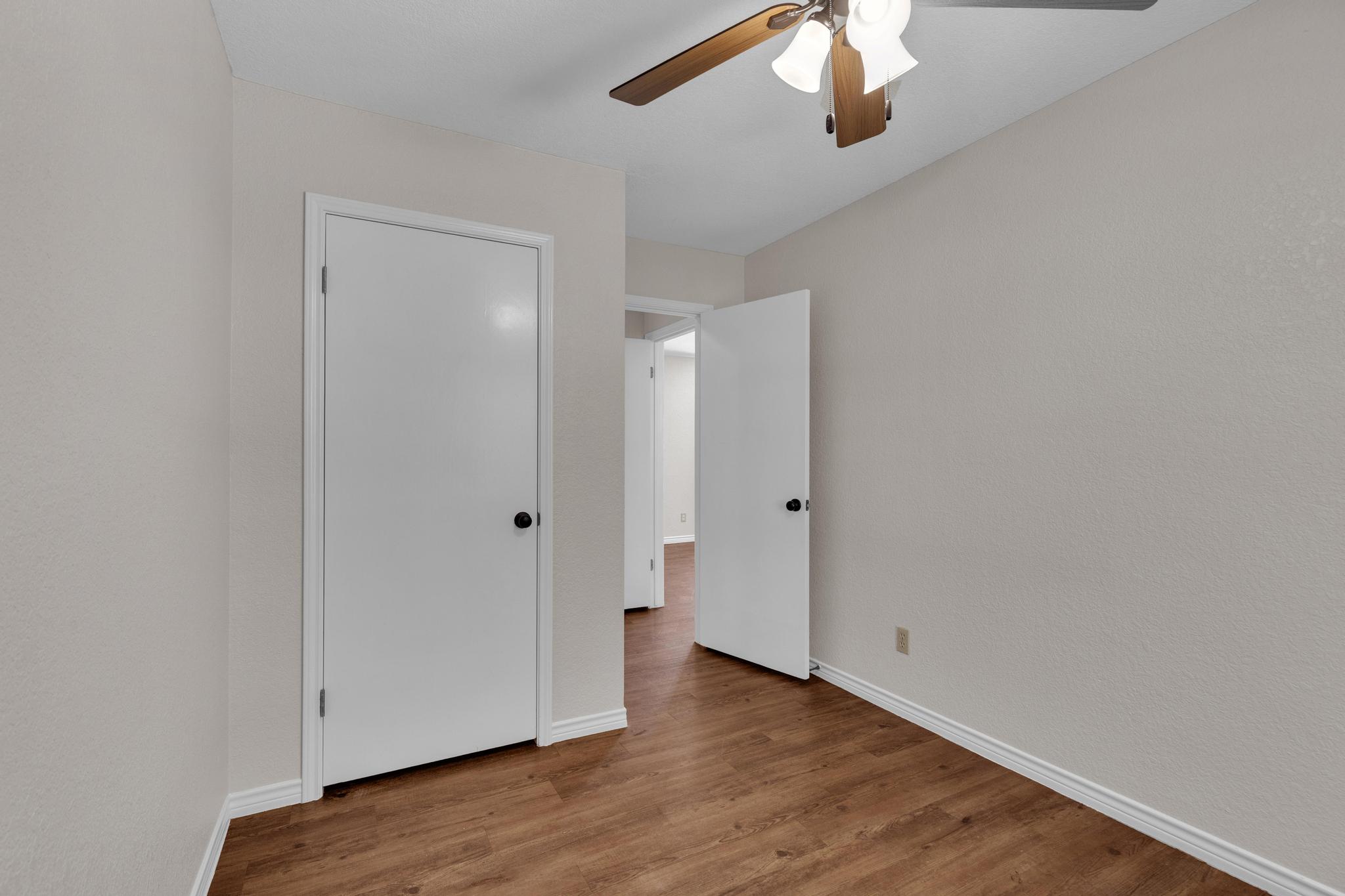 7902 Bar K Ranch Road Lago Vista, TX 78645 - Photo 23 of 35 Unfurnished bedroom featuring wood finished floors and ceiling fan