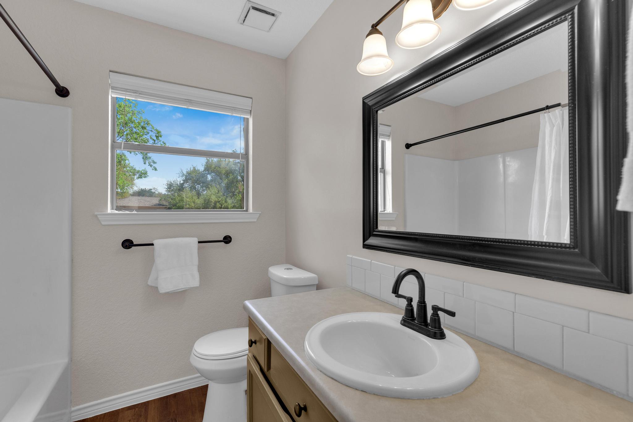7902 Bar K Ranch Road Lago Vista, TX 78645 - Photo 24 of 35 Bathroom featuring vanity, dark wood-style floors, and shower / bath combo