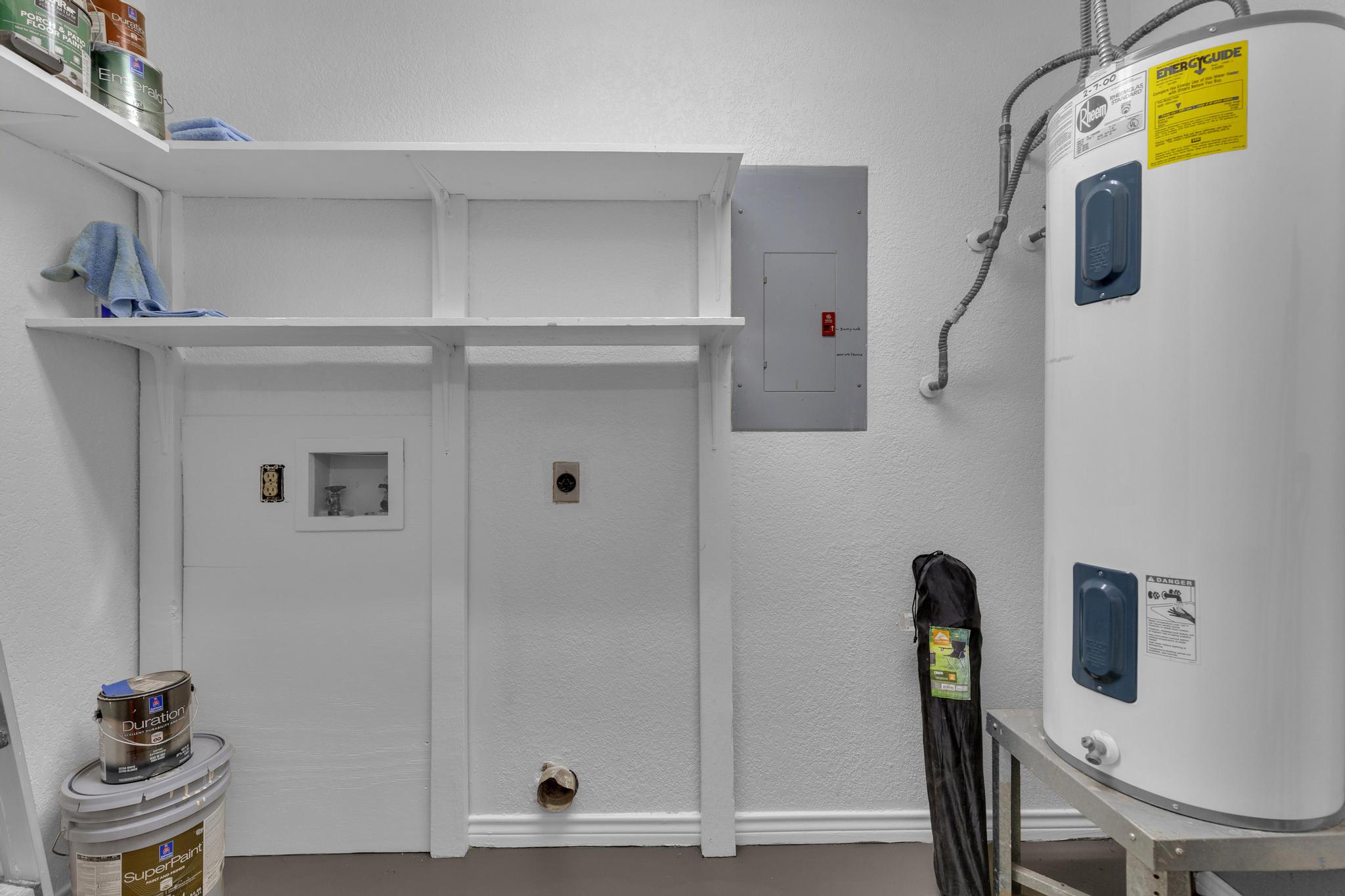 7902 Bar K Ranch Road Lago Vista, TX 78645 - Photo 26 of 35 Laundry room with a textured wall, electric water heater, electric panel, and washer hookup