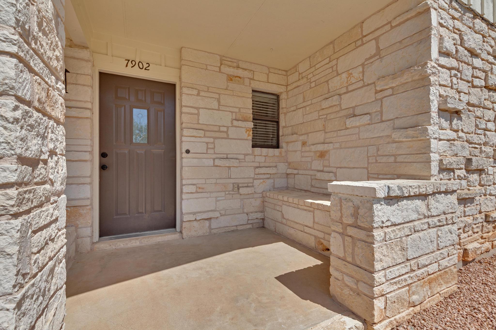 7902 Bar K Ranch Road Lago Vista, TX 78645 - Photo 28 of 35 Doorway to property with stone siding and covered porch