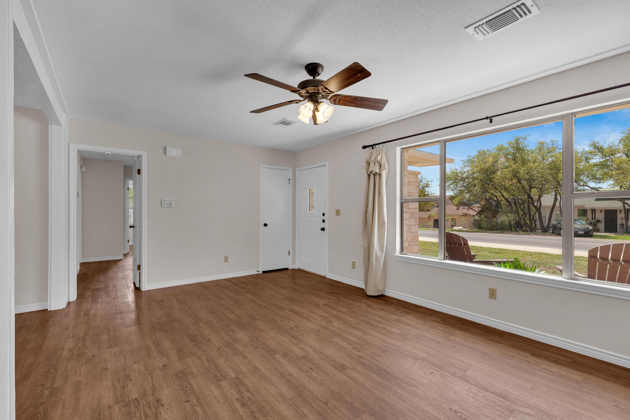 7902 Bar K Ranch Road Lago Vista, TX 78645 - Photo 5 of 35 Unfurnished room featuring ceiling fan, wood finished floors, and a textured ceiling