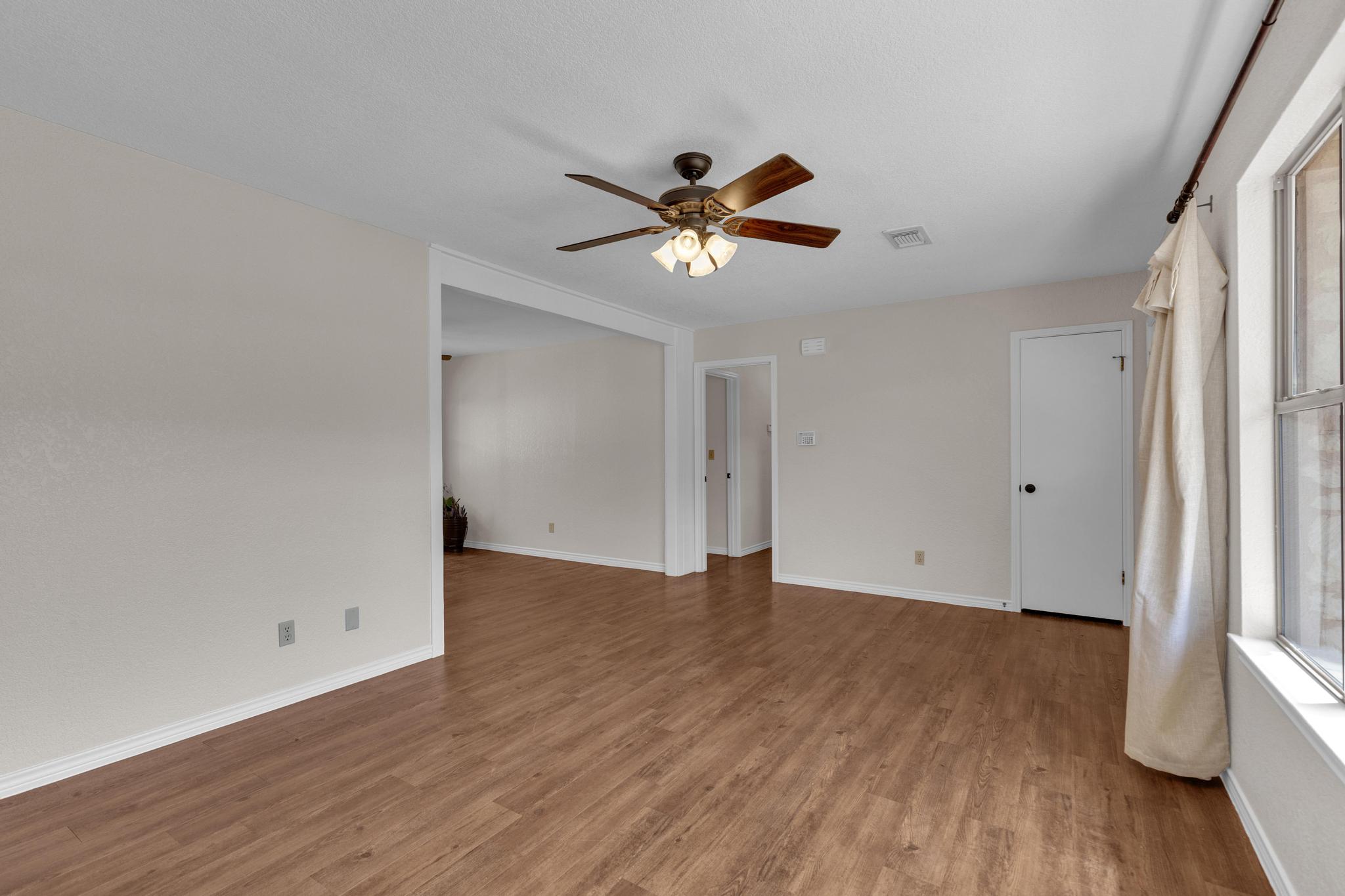 7902 Bar K Ranch Road Lago Vista, TX 78645 - Photo 6 of 35 Empty room featuring ceiling fan and light wood-type flooring