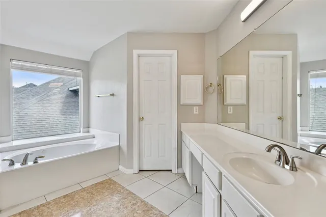 a spacious bathroom with a double vanity sink and a mirror